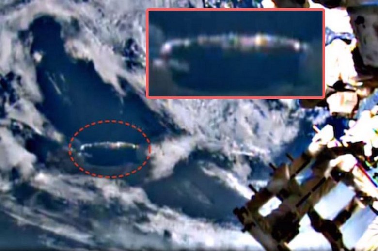 Um OVNI longo em forma de charuto se esconde nas nuvens abaixo da ISS